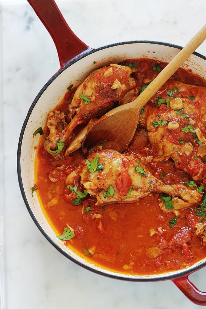 Cette recette de poulet à l’ail et tomates me vient de ma mère. C’est un plat savoureux et économique. Ce sont des morceaux de poulet cuits lentement et longuement dans une cocotte ou une grande poêle avec de l’ail et des tomates. Pas besoin de laisser mariner le poulet au préalable. Après cuisson, le poulet est très tendre, juteux et plein de saveurs.